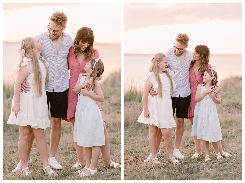 Golden Hour Family Shoot in Hampshire - Relaxed golden hour family portrait in Hampshire by Lucylou Photography. Elliott and Chantelle stand together with their daughters at Meon Shore, all smiling at the camera in soft evening light with the sea in the background