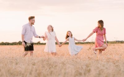 Best Locations for a Family Photoshoot in Hampshire | Professional Family Photos of family walking through the wheat fields