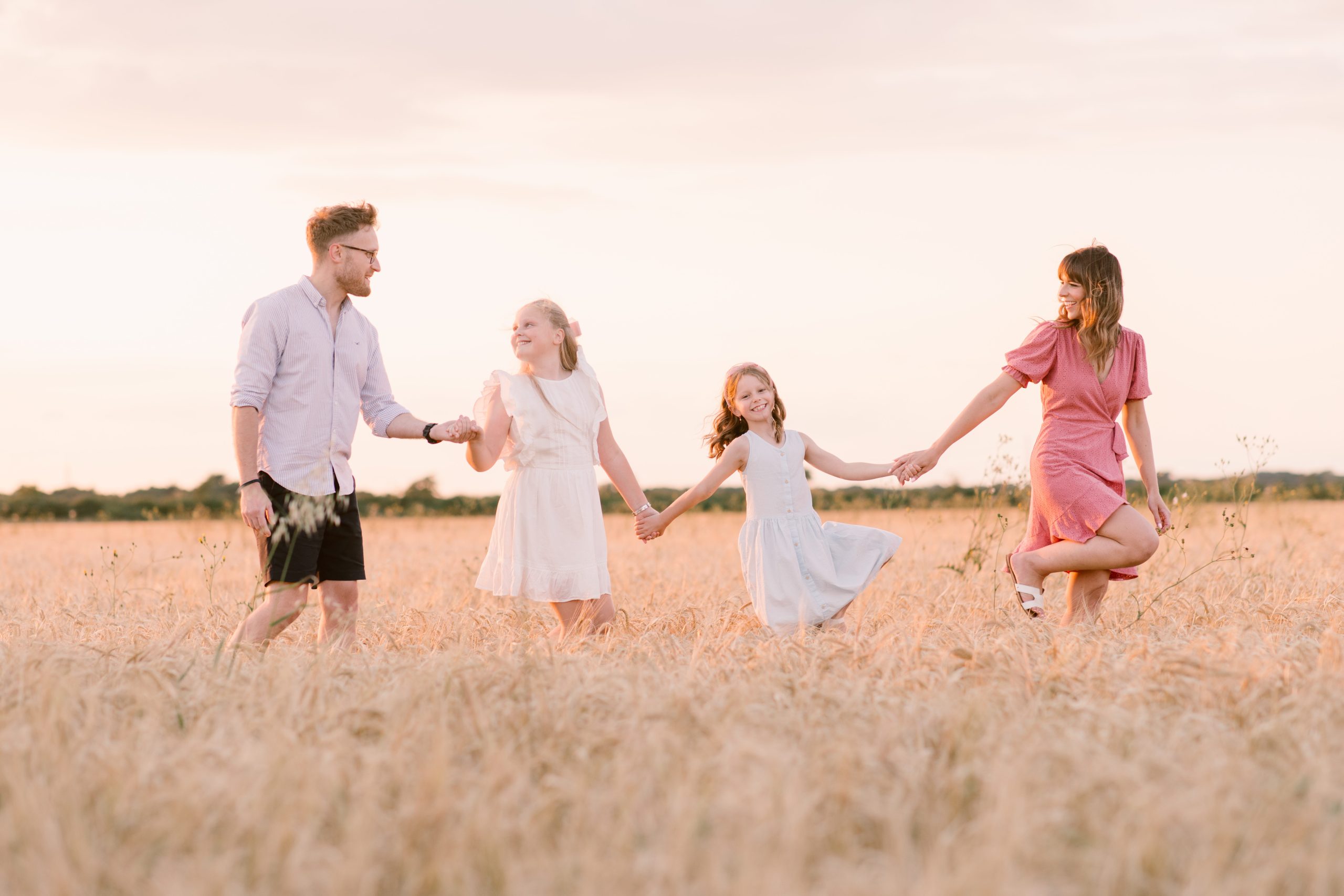 Professional Family Photos of family walking through the wheat fields