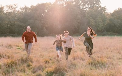 family all running through the grass and smiling - natural family photos - Hampshire Family Photographer