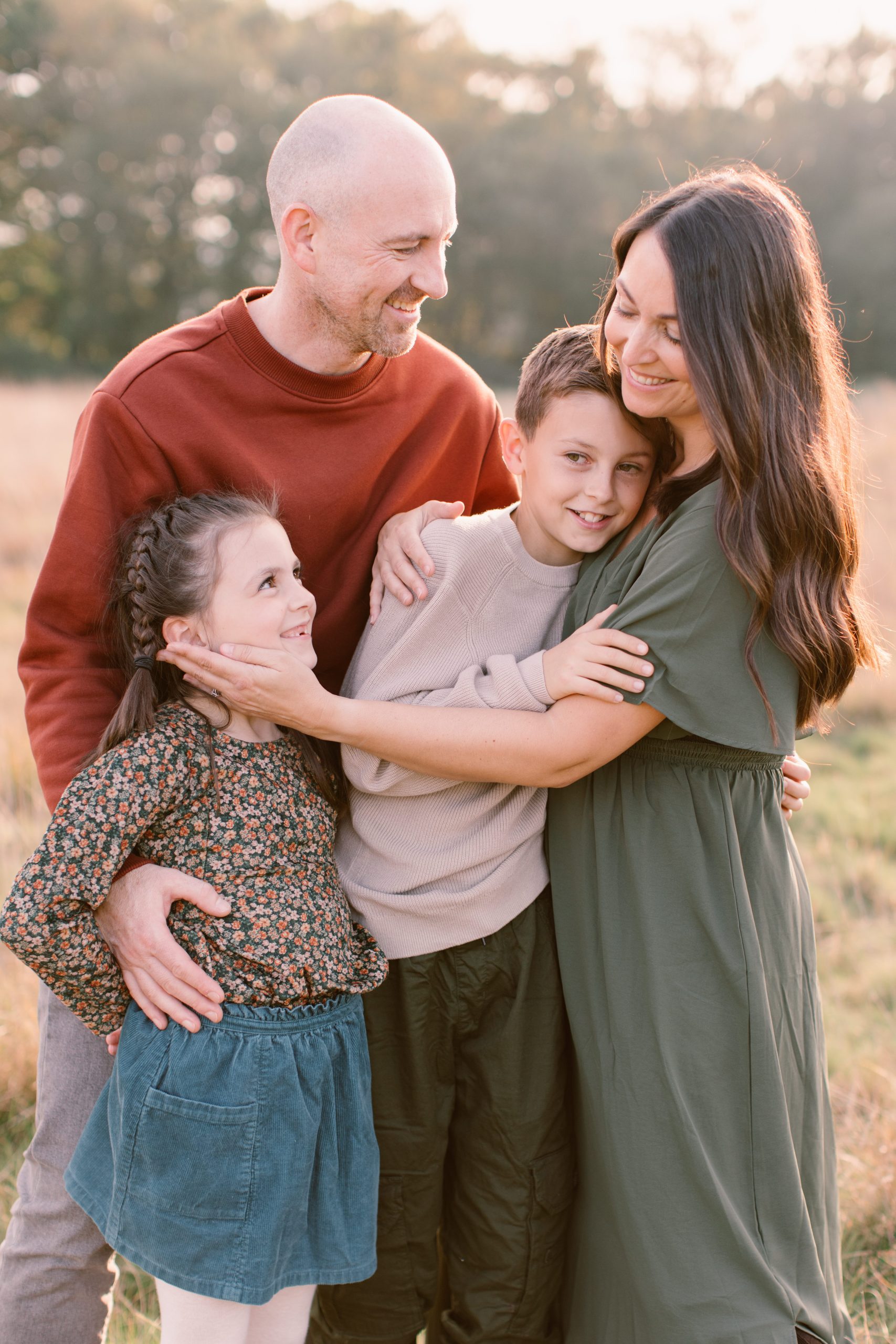 Beautiful family all cuddling together intimately and smiling at each other - Hampshire Family Photographer 